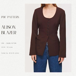 May include: A brown blazer with a scoop neckline and a button front. The blazer has a fitted waist and a long, pointed hem. The blazer is shown on a model wearing blue jeans.
