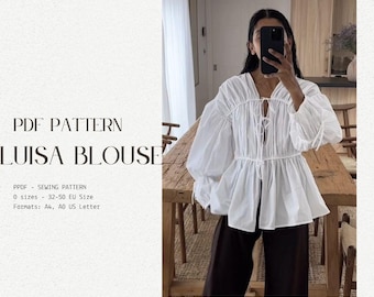 May include: A white blouse with a gathered neckline and a tie at the front. The blouse has long, puffy sleeves and a loose fit. The text "PDF PATTERN LUISA BLOUSE" is at the top of the image. The text "PPDF SEWING PATTERN 0 sizes 32-50 EU Size Formats: A4, AO US Letter" is at the bottom of the image.