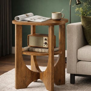 May include: A wooden side table with a triangular top and a lower shelf. The table features a light brown wood grain finish. On the top surface sits an open magazine and a ceramic mug. A vintage-style radio and a book rest on the lower shelf.