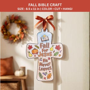 Puede incluir: Una manualidad de papel en forma de cruz que mide 21,59 por 27,94 cm, con una cinta marrón en la parte superior. El diseño incluye ilustraciones de una Biblia, una calabaza, peras y hojas de otoño, con el texto Fall For Jesus He Never Leaves.