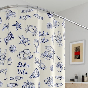 May include: Cream-colored shower curtain with a repeating pattern of blue illustrations. The design includes images of seafood, wine glasses, and the words "Dolce Vita". The curtain is hanging in a bathroom.