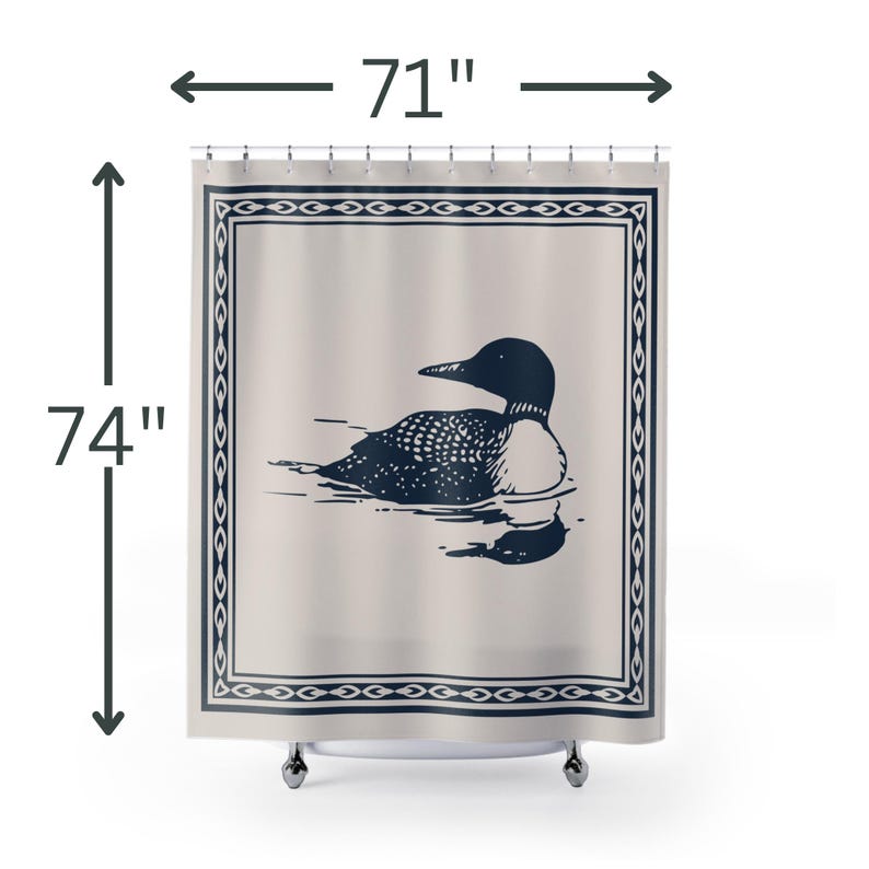 A white shower curtain featuring a navy blue illustration of a loon swimming on water. The loon is detailed with white spots and a black head. The curtain has a navy blue border with a decorative pattern.