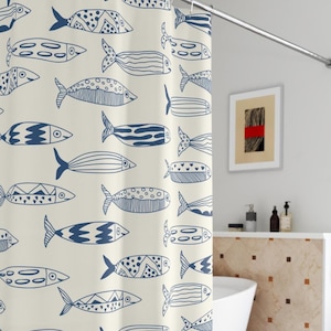 May include: Cream-colored shower curtain with a repeating pattern of blue fish in various designs. The fish have detailed patterns and are arranged in a whimsical, artistic style. The curtain is hanging on a silver rod.