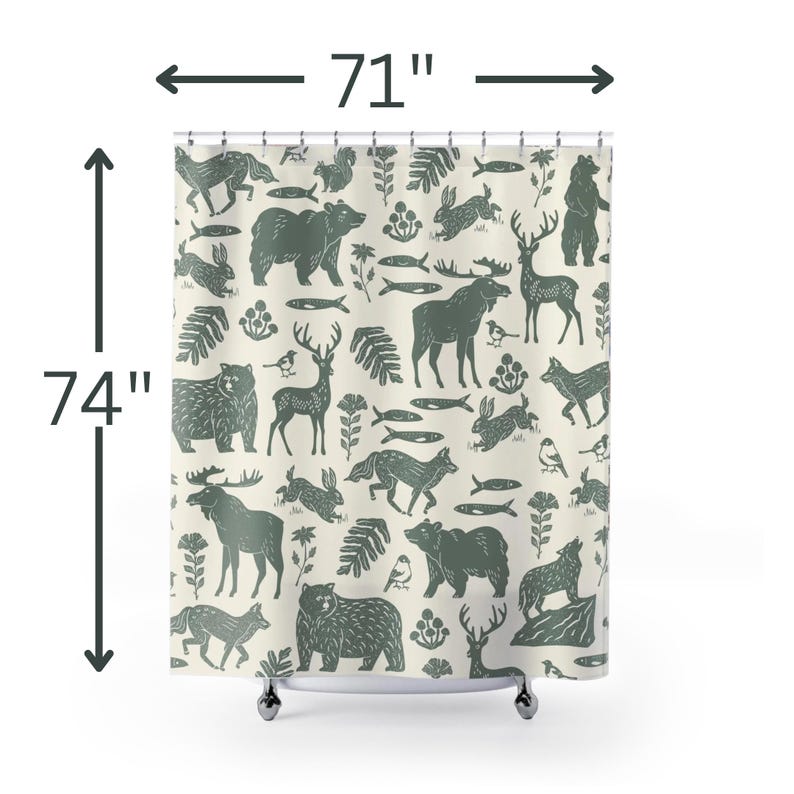 A shower curtain with a repeating pattern of forest animals in dark green on a cream background. The woodland design includes bears, deer, rabbits, foxes, birds, fish, and plants. The curtain has a whimsical log cabin aesthetic.