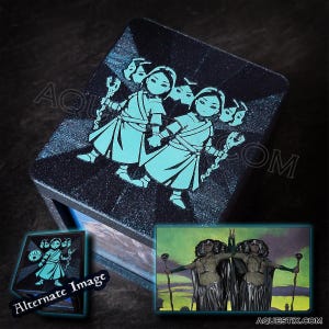 May include: A black wooden box with a blue and white image of two figures with masks on their faces. The box has a small window on the side that shows a different image of three figures with masks on their faces.