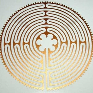 May include: A circular, gold-coloured labyrinth design with a flower-shaped centre. The labyrinth is made up of concentric circles and winding paths.
