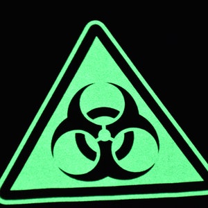 May include: A green glow-in-the-dark triangle warning sign with a black biohazard symbol.