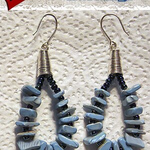 May include: A pair of drop earrings featuring a teardrop-shaped loop of light blue stone chips and small dark metallic beads. The earrings have silver-toned metal cones at the top and hook wires. The text "Tutorial Blue Chip Earrings" is visible.