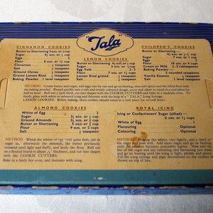 Puede incluir: Una caja vintage de cortadores de galletas "Tala" con recetas para galletas de canela, lim&oacute;n, para ni&ntilde;os, de almendras y glaseado real. La caja es azul y blanca con un inserto de cart&oacute;n marr&oacute;n.