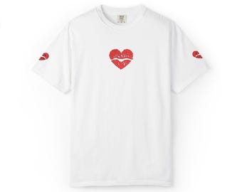 May include: White t-shirt with a red heart-shaped lip print on the front and a smaller lip print on each sleeve. The shirt has a classic crew neck and short sleeves, perfect for casual wear.