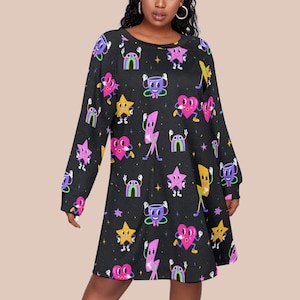 May include: Black long-sleeve dress with a repeating pattern of cartoon characters. The design includes stars, hearts, rainbows, lightning bolts, and coffee cups in various colors. The dress has a crew neck and a relaxed fit.