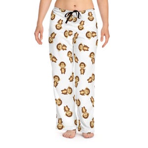 May include: White pajama pants with a repeating pattern of brown monkeys. The monkeys are smiling and have brown fur.