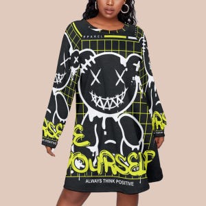 May include: Black long-sleeve dress with a large white and yellow graphic of a bear with stitched details and a wide grin. The dress features the text "RISE YOURSELF" and "ALWAYS THINK POSITIVE" in yellow.