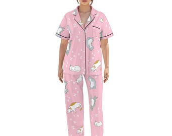 May include: Pink pyjama set featuring a repeating pattern of sleeping cats in various poses. The short-sleeved top and trousers are trimmed with black piping. The pyjamas are made of a soft, comfortable material.