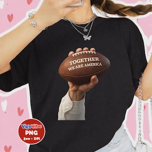 Może przedstawiać: Czarny t-shirt z brązową piłką do futbolu amerykańskiego z napisem "TOGETHER WE ARE AMERICA". Piłka jest trzymana w dłoni. Obraz zawiera również bransoletkę i naszyjnik.