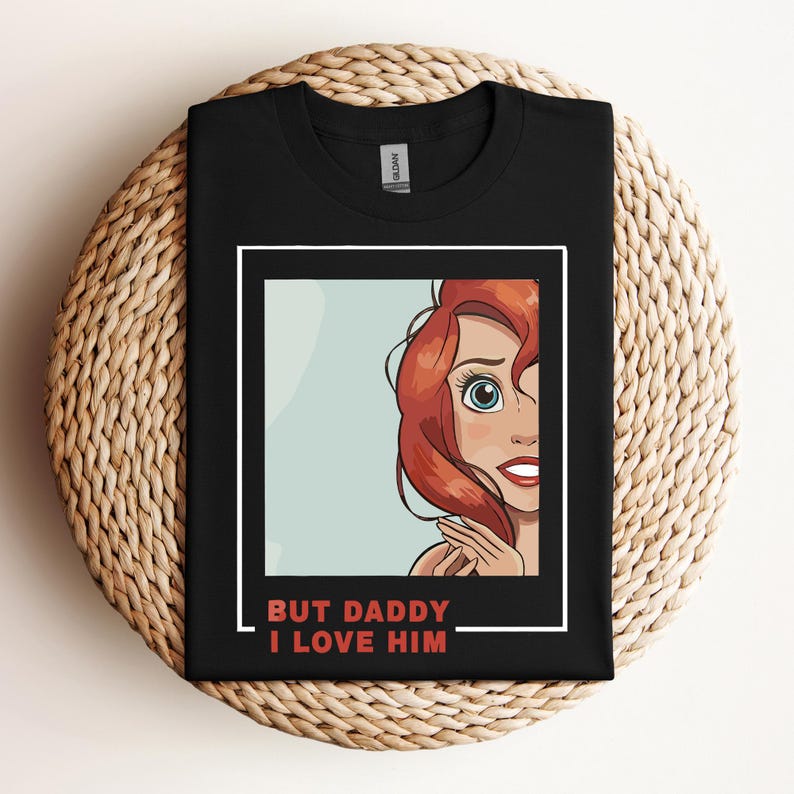 May include: Black t-shirt featuring a red cartoon image of a woman with red hair and the text "But Daddy I Love Him" in red.