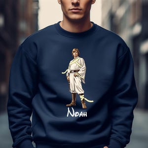 May include: Navy blue sweatshirt featuring a stylized illustration of a character in a white outfit with a yellow sash. The character is standing with a weapon. The name "Noah" is written in white script below the character.