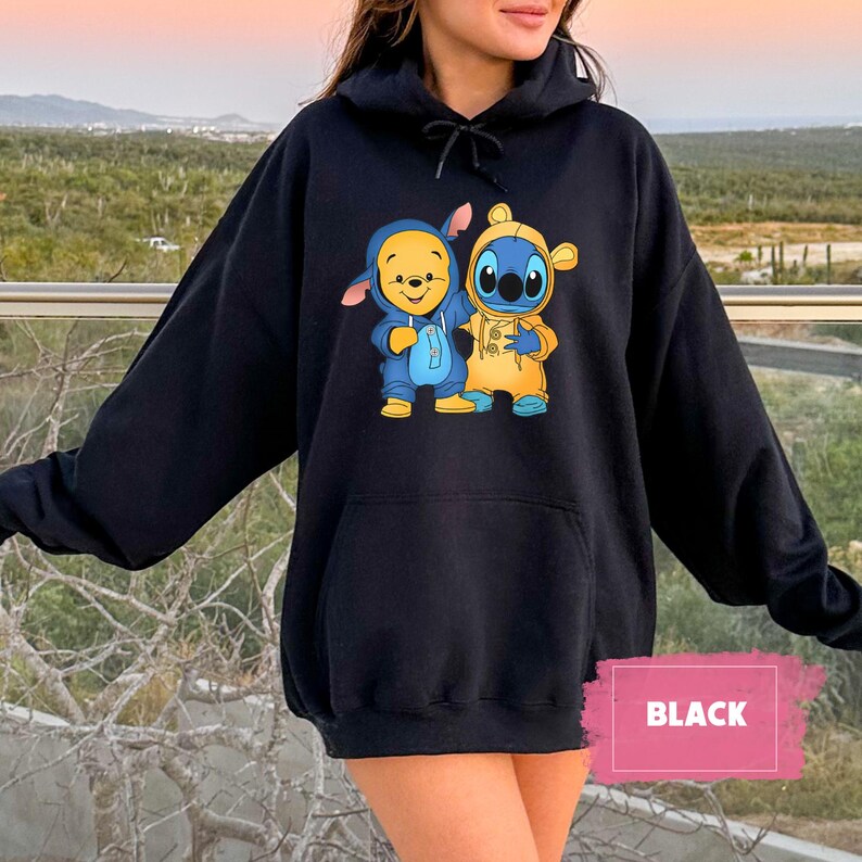 May include: Black hoodie with a graphic of Stitch and Winnie the Pooh dressed in each other's costumes. The text "BLACK" is visible in the lower right corner of the image.