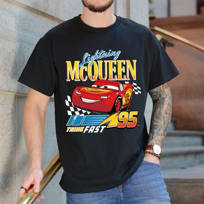 Puede incluir: Camiseta negra con un dise&ntilde;o de Rayo McQueen de la pel&iacute;cula Cars. El dise&ntilde;o incluye el texto "Lightning McQueen" en amarillo y el n&uacute;mero "95". Tambi&eacute;n se incluye la frase "Think Fast".