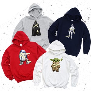May include: Four hooded sweatshirts in gray, navy, red, and white. Each sweatshirt features a graphic of a Star Wars character wrapped in bandages. Characters include Darth Vader, a Stormtrooper, R2-D2, and Grogu.