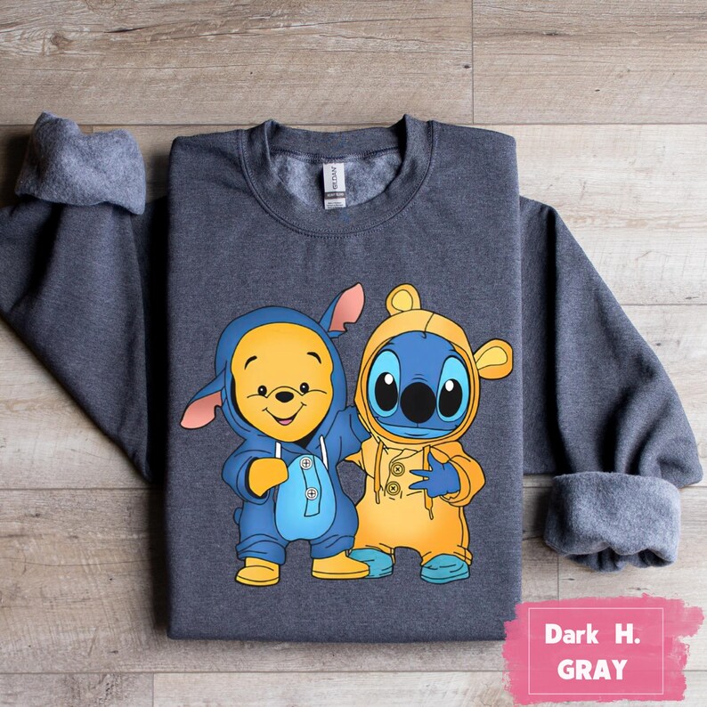 May include: Dark heather gray sweatshirt with a cartoon image of Winnie the Pooh and Stitch wearing blue and yellow hooded outfits.