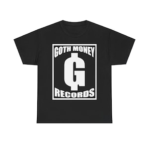 Könnte beinhalten: Schwarzes T-Shirt mit einem weißen Grafikdruck eines Dollarzeichens mit dem Buchstaben G darin. Die Grafik befindet sich in einem Kasten mit dem Text "GOTH MONEY RECORDS" darüber und darunter.