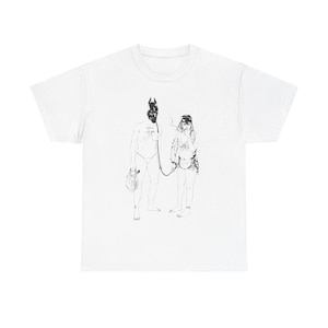 May include: White t-shirt featuring a black and white illustration of two figures. One figure is wearing a mask and holding a leash attached to the other figure.