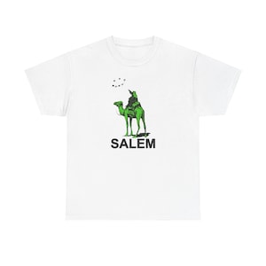 May include: White t-shirt with a green camel and rider graphic and the word "SALEM" printed in black below the image.