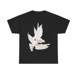 Pode incluir: Camiseta preta com um gráfico de duas pombas brancas em voo.