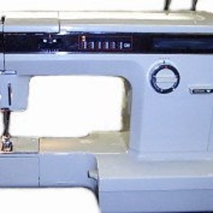 Puede incluir: Una máquina de coser vintage blanca con una aguja negra y un pedal. La máquina tiene una pantalla digital y una variedad de opciones de puntadas.