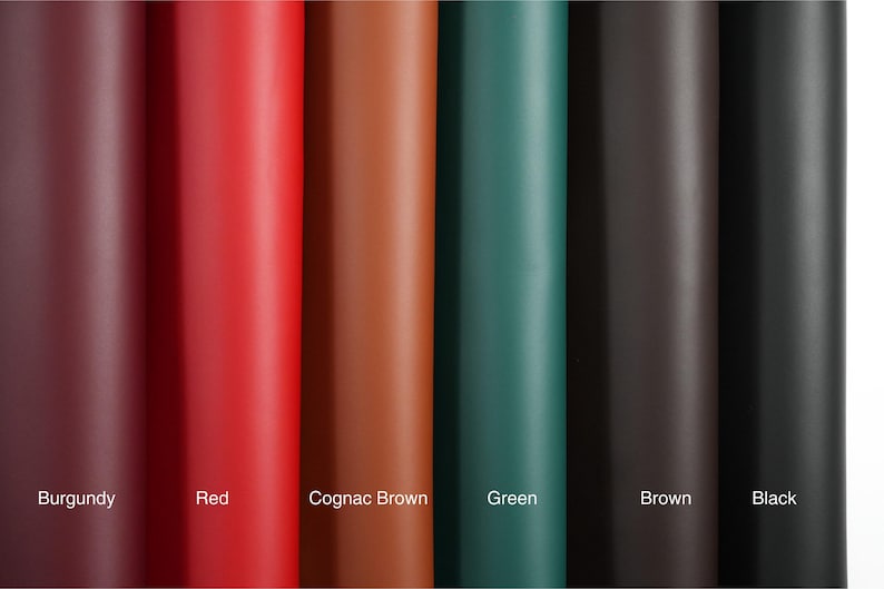 A top view of rolled top grain premium Italian leather, 4.5-5 oz, in various colors: brown, black, green, red, burgundy, and cognac brown—perfect for crafting projects.