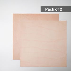 May include: Two square sheets of light tan, smooth-textured material stacked slightly offset. The top right corner features a dark gray rectangular label with white text that reads Pack of 2. The sheets have a natural, matte finish.