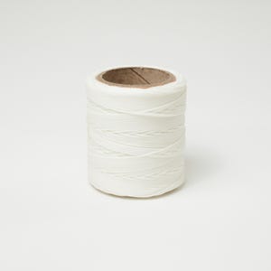 May include: A spool of white cord, tightly wound around a cardboard core. The cord appears to be made of a smooth, synthetic material. The spool is cylindrical and stands upright against a white background.
