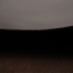 Close-up of the edge of top grain premium Italian leather, 4.5-5 oz, brown leather ideal for crafting projects like bags, wallets, and accessories.