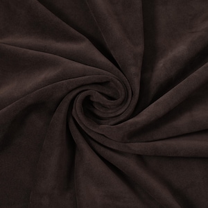 May include: A dark brown fabric with a soft, matte, suede-like texture. The material is gathered into a central spiral, creating deep, flowing folds and shadows that highlight the uniform, solid color and the smooth, non-reflective surface.