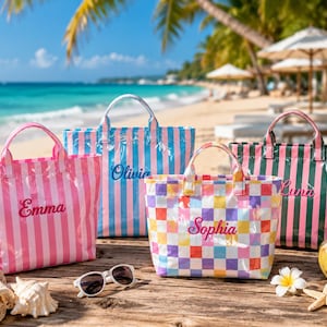 Peut inclure: Quatre sacs fourre-tout colorés, chacun brodé d'un nom. Les sacs sont rayés en rose, bleu et vert, et l'un est à carreaux. Ils sont posés sur une surface en bois avec une scène de plage en arrière-plan.