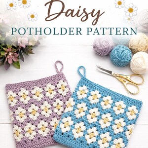 May include: Two crocheted daisy potholders, one lilac and one blue, with white and yellow daisy patterns. The image also includes yarn balls, scissors, and text that reads "CROCHET Daisy Potholder Pattern."