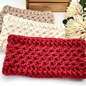 May include: Three crocheted headbands in different colours: beige, white and red. The headbands are made with a textured stitch pattern.