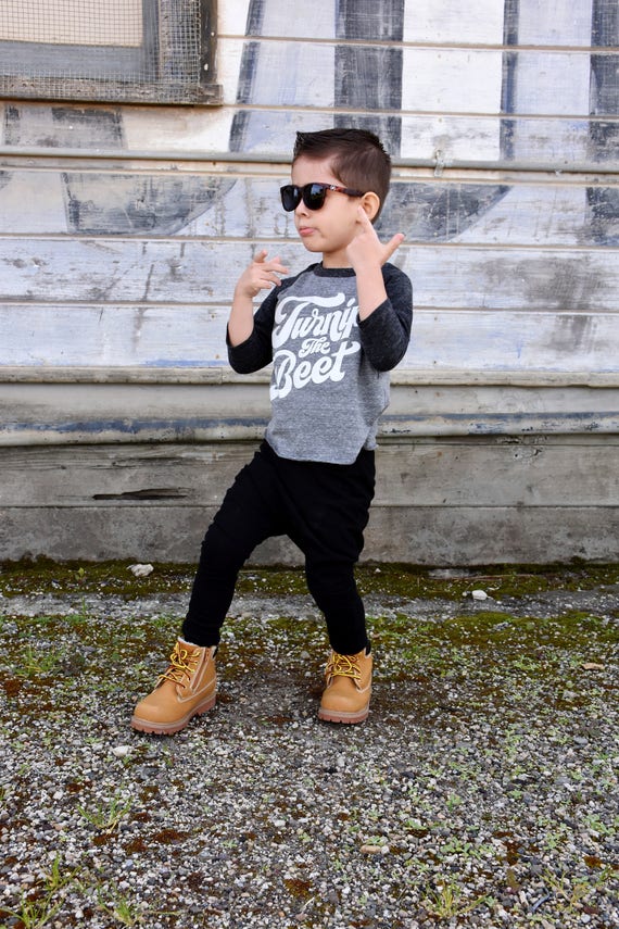 Premium Photo  Toddler boy in black hat and black pants with a naked torso  sits on a gray neutral background