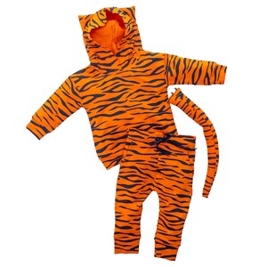 May include: Orange and black tiger print hooded sweatshirt and matching pants with a tail. The set is made for a baby or toddler.