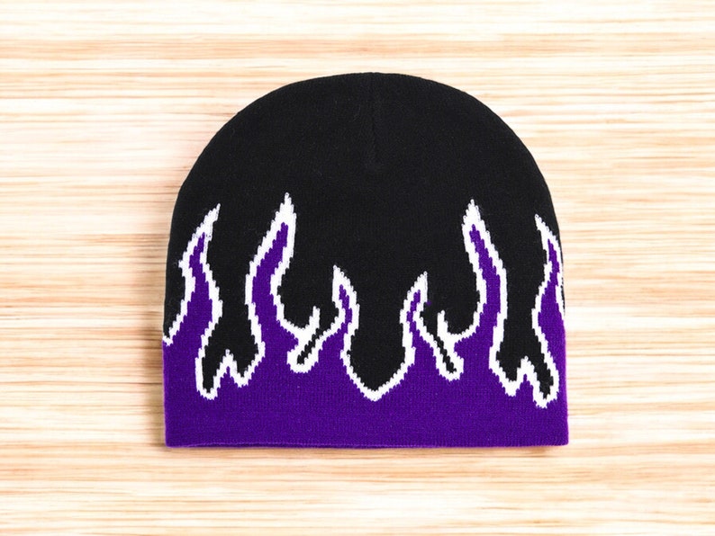Puede incluir: Gorro negro con dise&ntilde;o de llamas moradas y blancas.