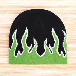 Puede incluir: Gorro negro con dise&ntilde;o de llamas verdes y blancas.