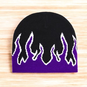 Puede incluir: Gorro negro con dise&ntilde;o de llamas moradas y blancas.
