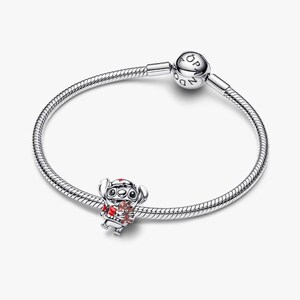 Op de afbeelding: Een zilveren armband met een Stitch-bedel. De bedel heeft rode en bruine details. De armband heeft een ronde sluiting met de letters "PANDORA".