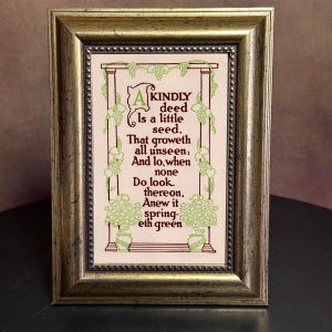 May include: A framed print with a gold-colored frame. The print features a poem with green and brown accents. The poem's text is in a decorative font, and the artwork includes floral and grape vine motifs.