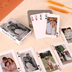 May include: A deck of playing cards with custom photos, including the Ace of Hearts, 2 of Hearts, King of Spades, and Queen of Clubs. The card box is white with a photo and the text "Nicole & Joseph 10.06.2025 Playing Cards".