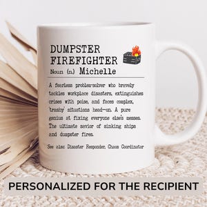 May include: White ceramic mug with a black and white design that reads "DUMPSTER FIREFIGHTER Noun (n.) Michelle A fearless problem-solver who bravely tackles workplace disasters, extinguishes crises with poise, and faces complex, 'trashy' situations head-on. A pure genius at fixing everyone else's messes. The ultimate savior of sinking ships and dumpster fires. See also: Disaster Responder, Chaos Coordinator PERSONALIZED FOR THE RECIPIENT"