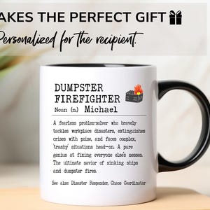 May include: White ceramic mug with a black handle. The mug has a black rim and a black graphic of a burning dumpster. The text on the mug reads "DUMPSTER FIREFIGHTER Noun (n.) Michael A fearless problem-solver who bravely tackles workplace disasters, extinguishes crises with poise, and faces complex, trashy situations head-on. A pure genius at fixing everyone else's messes. The ultimate savior of sinking ships and dumpster fires. See alsx Disaster Responder, Chaos Coordinator"