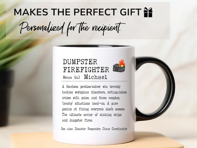 May include: White ceramic mug with a black handle. The mug has a black rim and a black graphic of a burning dumpster. The text on the mug reads "DUMPSTER FIREFIGHTER Noun (n.) Michael A fearless problem-solver who bravely tackles workplace disasters, extinguishes crises with poise, and faces complex, trashy situations head-on. A pure genius at fixing everyone else's messes. The ultimate savior of sinking ships and dumpster fires. See alsx Disaster Responder, Chaos Coordinator"