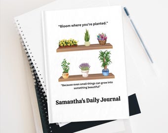May include: A white journal with a floral design and the text "Bloom where you're planted." and "Because even small things can grow into something beautiful." The journal is titled "Samantha's Daily Journal".